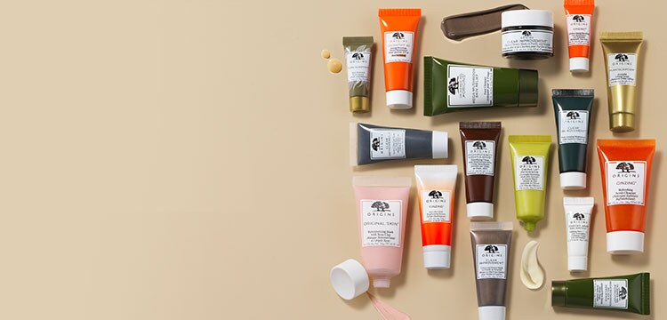 Un éventail de mini soins de la peau Origins de format voyage sur fond beige